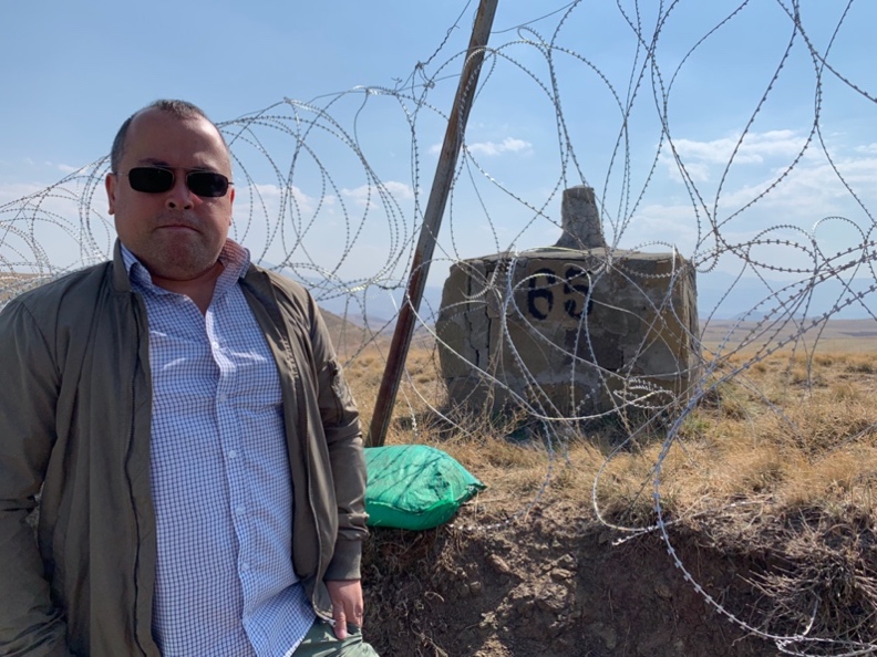 A person standing in front of barbed wire

Description automatically generated