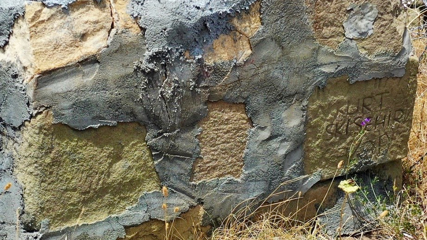 A close-up of a stone wall

Description automatically generated